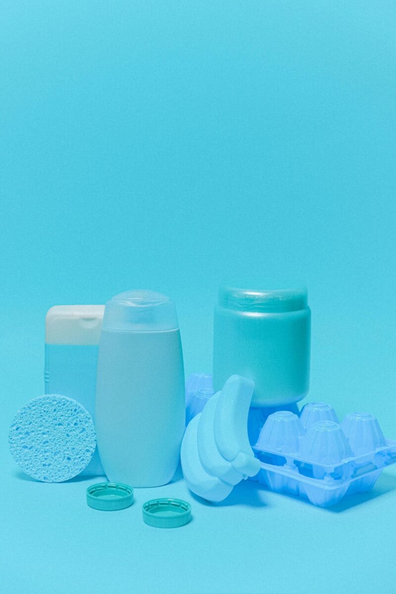 Collection of blue colored plastic containers with lids and egg tray isolated on blue background